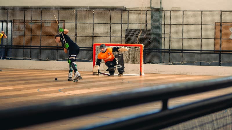 A dynamic moment captured during a roller hockey game with players in action on the court.