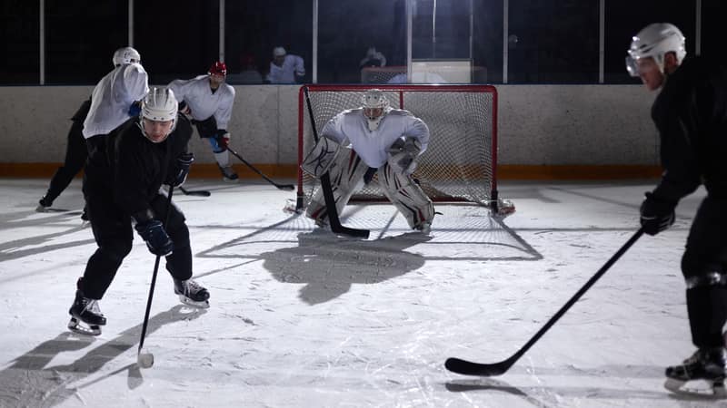 A dynamic moment captured during an ice hockey practice game in an indoor rink.