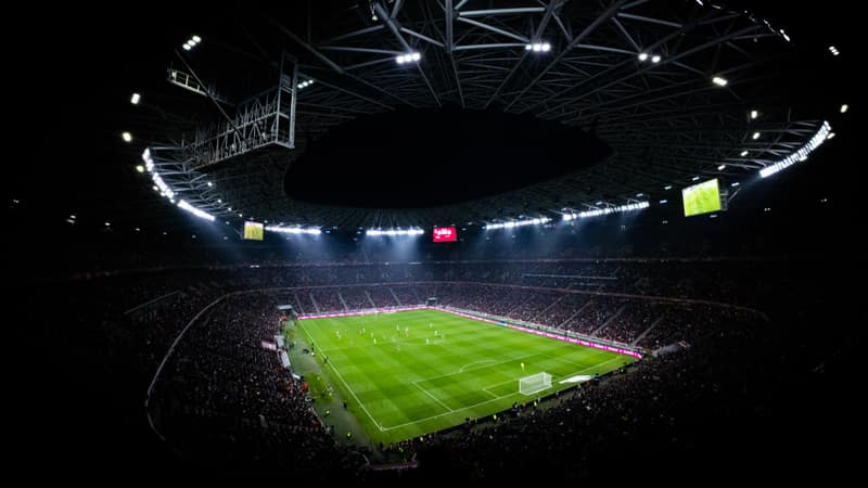 Aerial view of a night football match in Budapest. Illuminated stadium full of fans adds dramatic atmosphere.